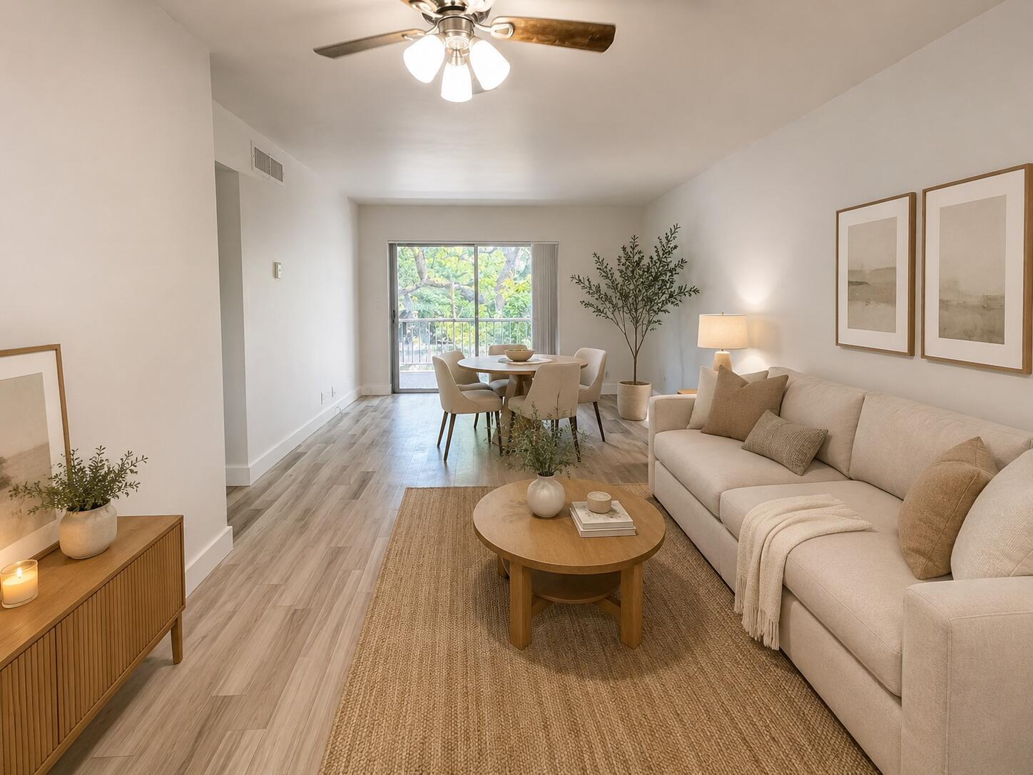 A bright living and dining area features light wood flooring, a beige sofa, and balcony — 610 NW 13th Street # 210, Boca Raton FL 33486, BOCA RATON, FL