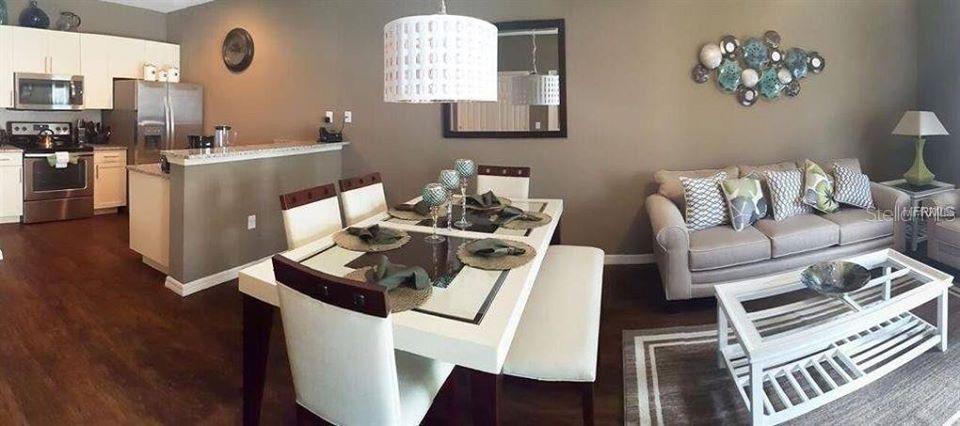 An open-concept living and dining area features a kitchen, a dining table, and a sofa — 9004 SHINE DRIVE UNIT 9004, KISSIMMEE, FL