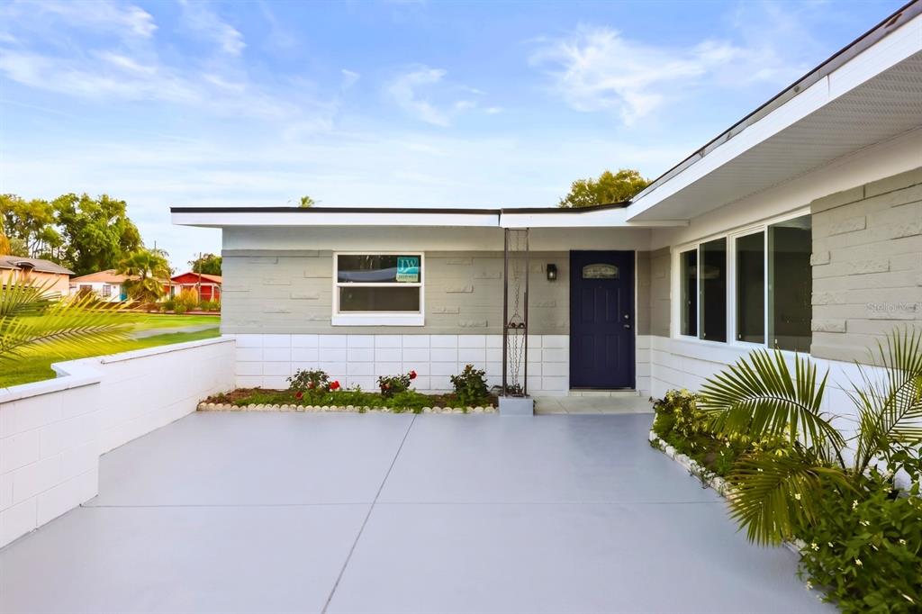 A single-story house exterior features a gray and white facade, a dark blue door, and a patio — 4528 S SHORE ROAD, ORLANDO, FL