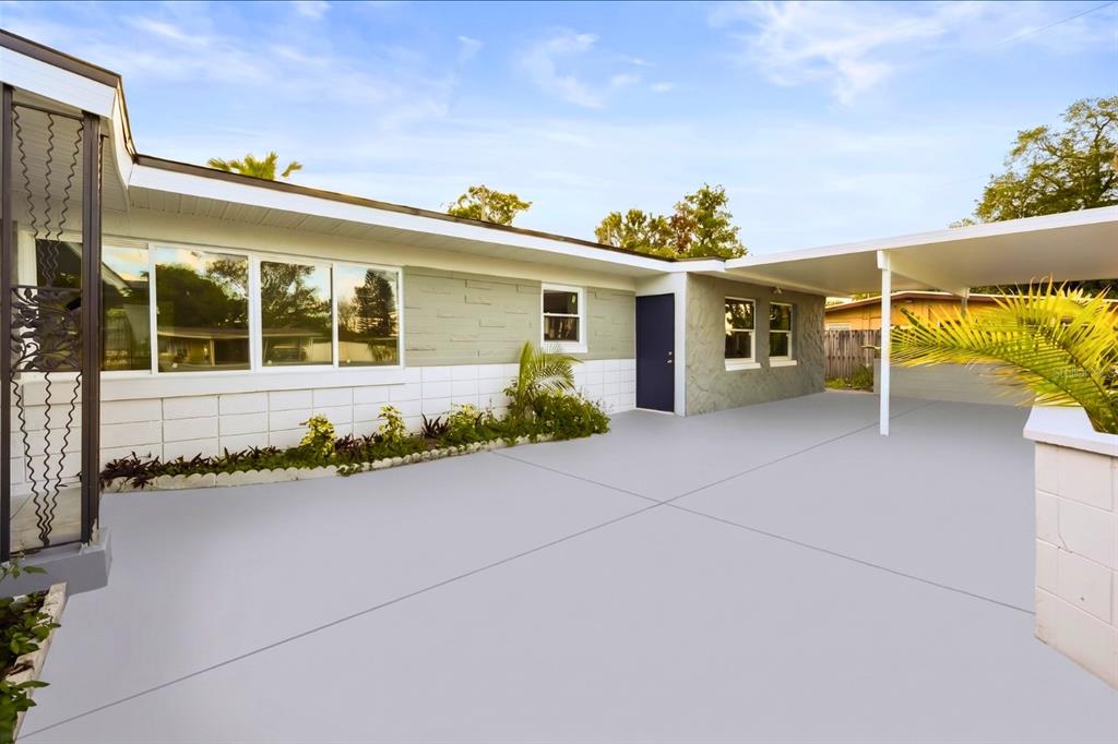 A paved driveway leads to a house exterior with a carport and a blue door — 4528 S SHORE ROAD, ORLANDO, FL