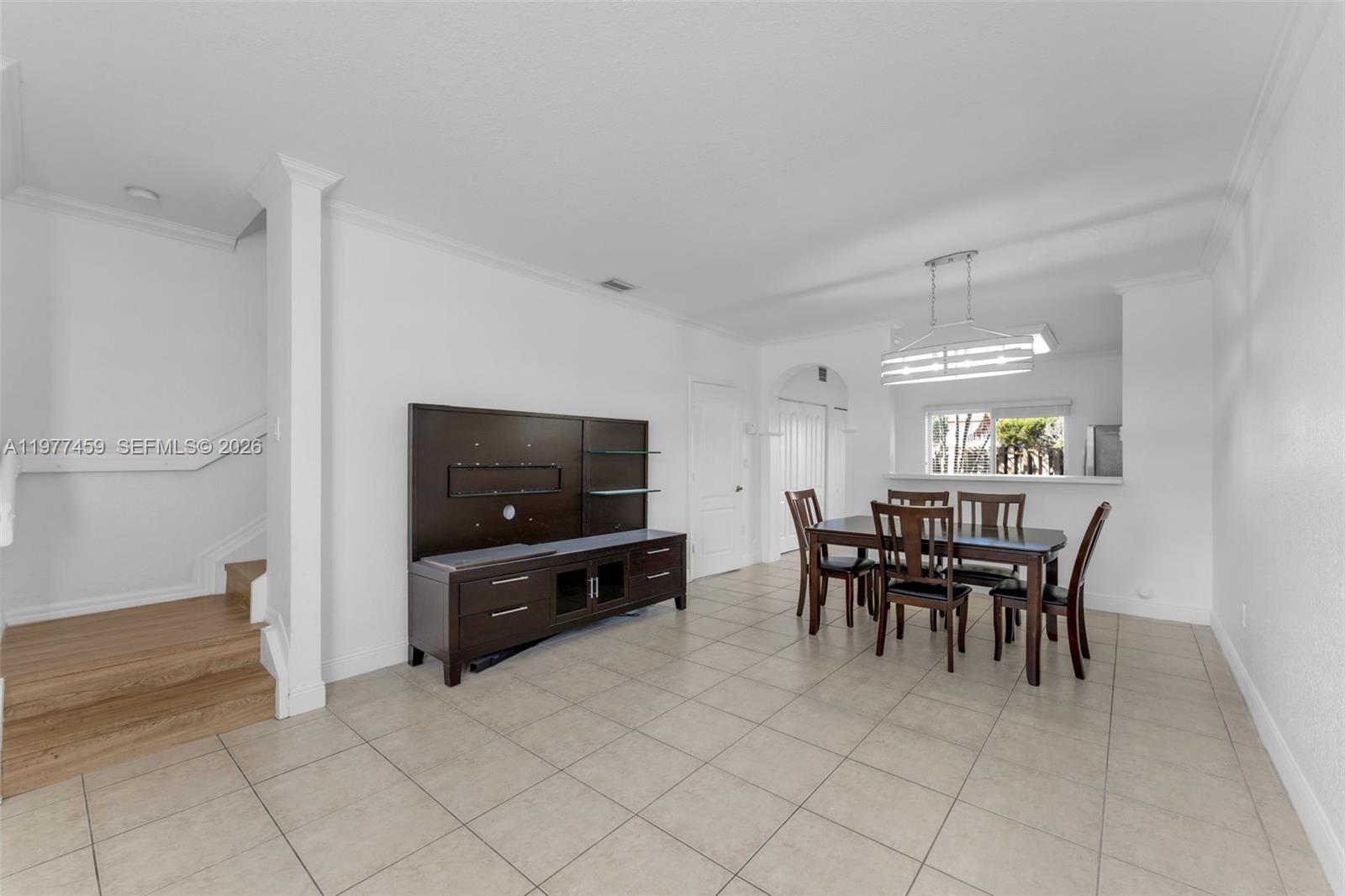 A dining area with a wooden table, chairs, and a media console on tile floors — 17040 SW 137th Pl, Miami FL 33177, MIAMI, FL