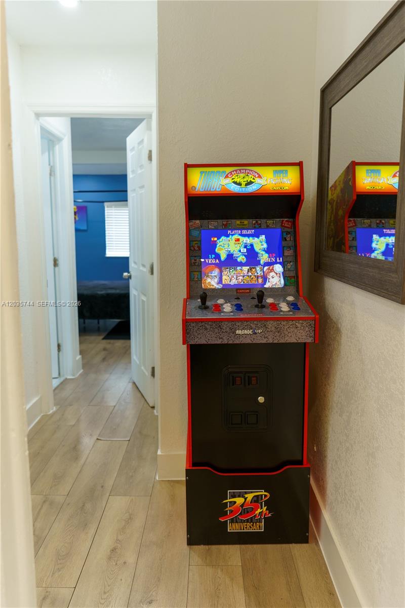 A hallway features a Street Fighter arcade cabinet next to a mirror and a doorway — 310 NE 162nd St, Miami FL 33162, MIAMI, FL