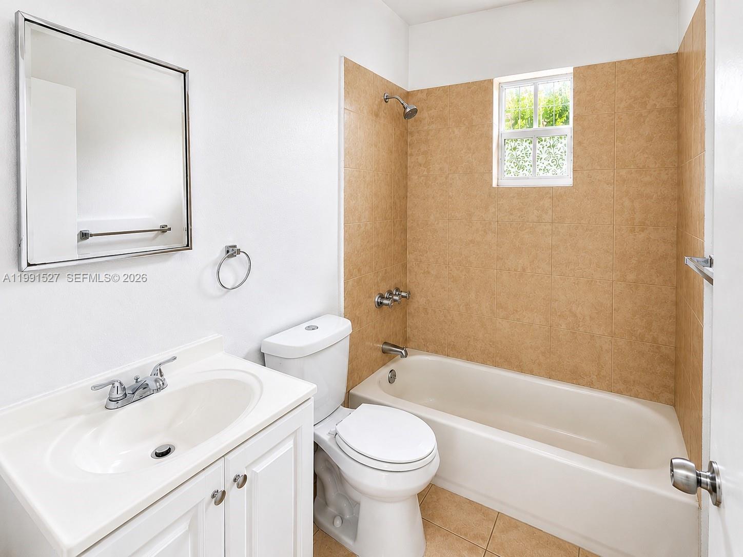 A bathroom features a white vanity, a toilet, and a bathtub with tan tile walls — 2047 Lincoln Ave # 4, Opa-Locka FL 33054, OPA-LOCKA, FL