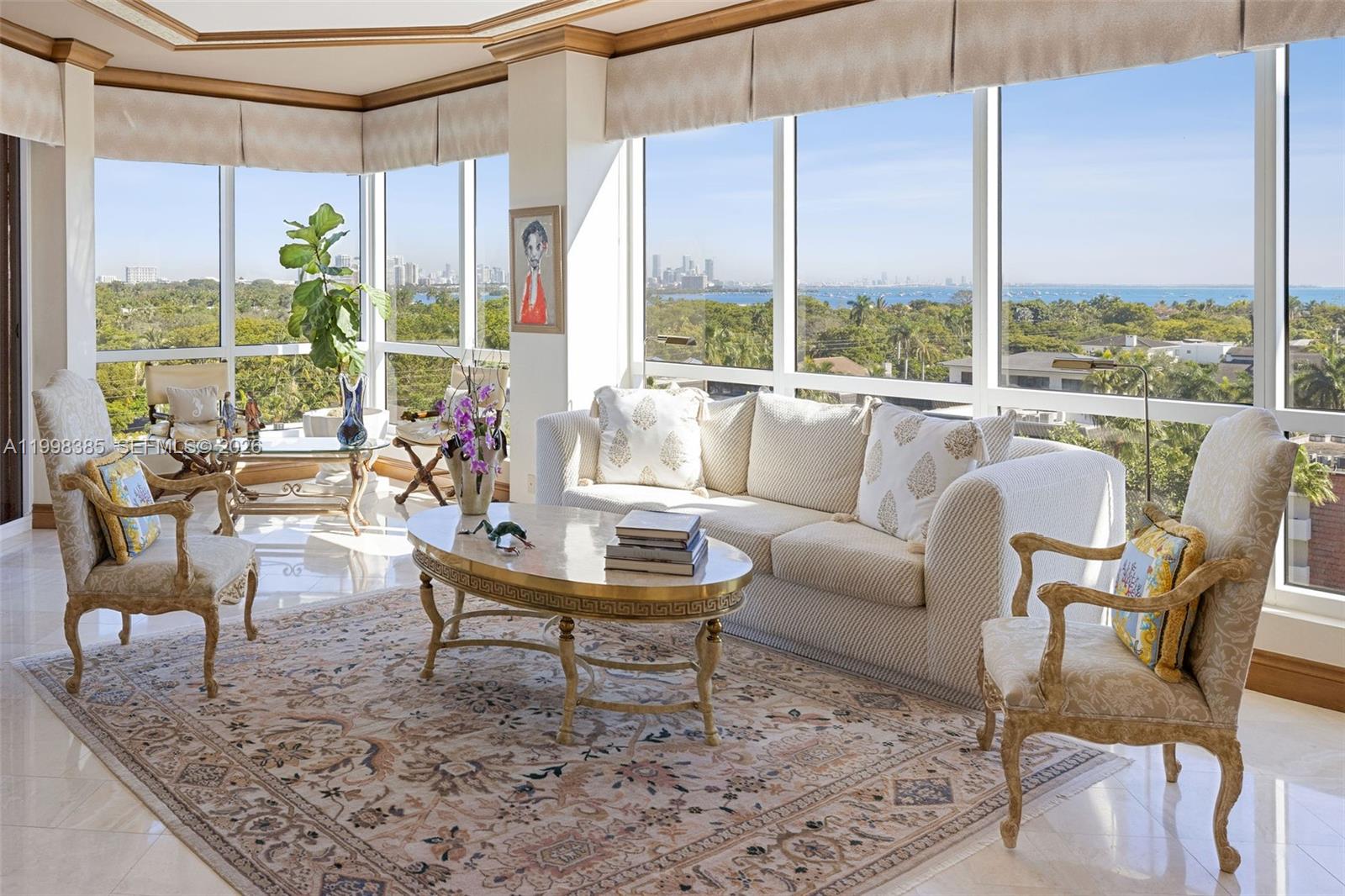 A bright living room features a sofa, armchairs, and floor-to-ceiling windows with panoramic water views — 10 Edgewater Dr # 7G, Coral Gables FL 33133, CORAL GABLES, FL