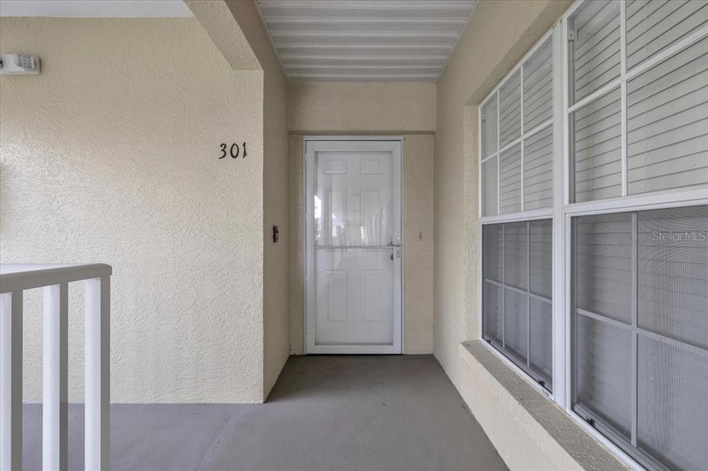 An exterior view of a residential apartment entrance with a white door and windows — 19335 WATER OAK DRIVE UNIT 301, PORT CHARLOTTE, FL