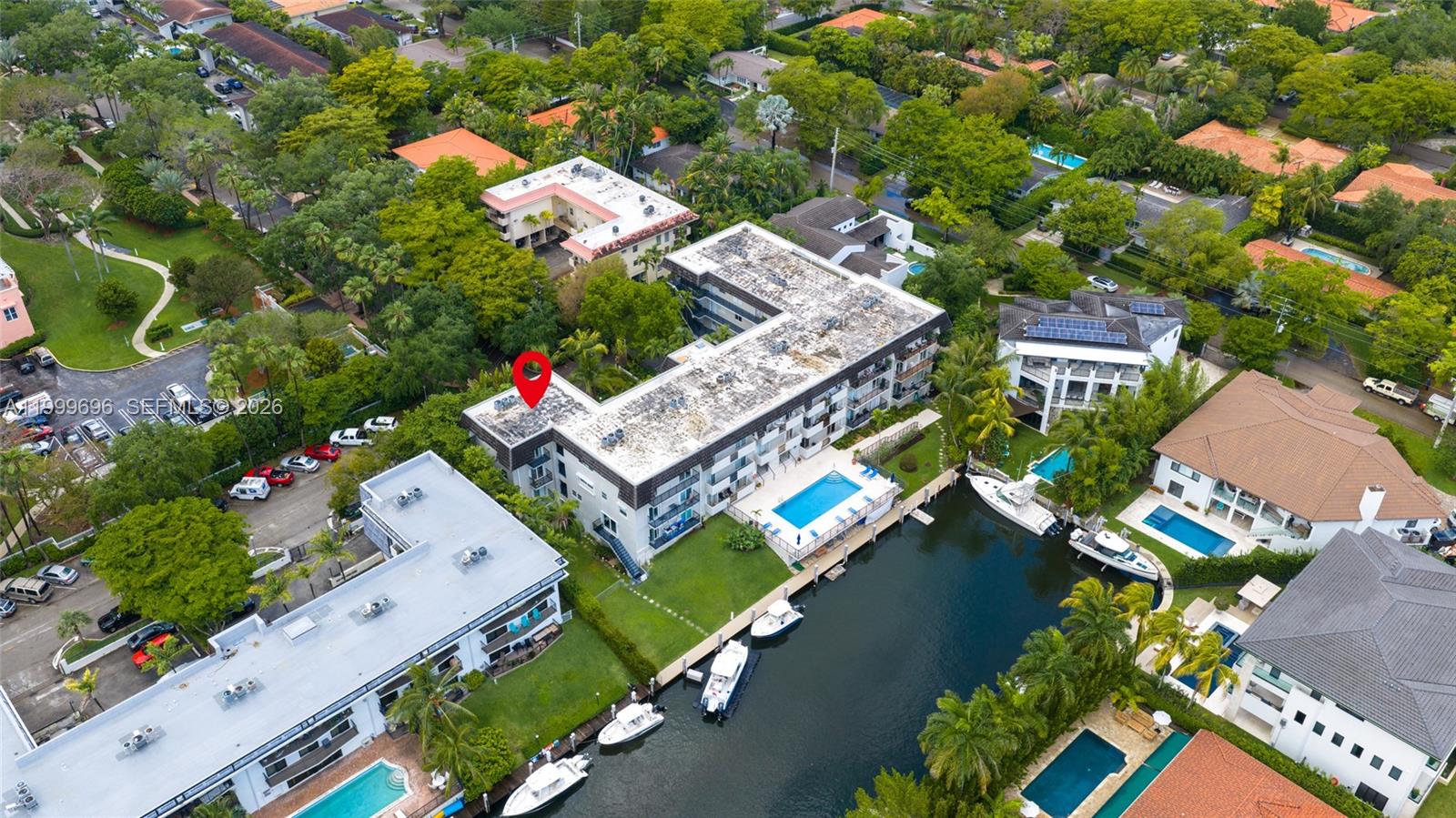 An aerial view shows a multi-story apartment building with a pool and boat slips — 6815 Edgewater Dr # 108, Coral Gables FL 33133, CORAL GABLES, FL