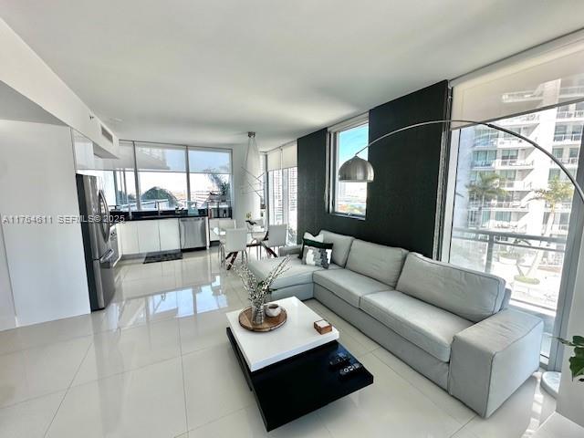 A modern living room features a light gray sectional sofa, white tile floors, and floor-to-ceiling windows — 92 SW 3rd St # 1410, Miami FL 33130, MIAMI, FL