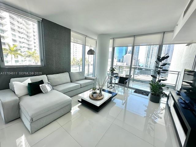 A modern living room features a light gray sectional sofa, a coffee table, and floor-to-ceiling windows — 92 SW 3rd St # 1410, Miami FL 33130, MIAMI, FL