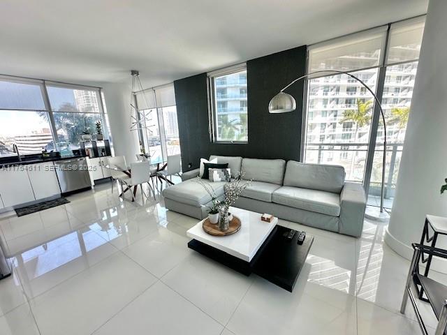 A modern living room features a light gray sectional sofa, white tile floors, and floor-to-ceiling windows — 92 SW 3rd St # 1410, Miami FL 33130, MIAMI, FL