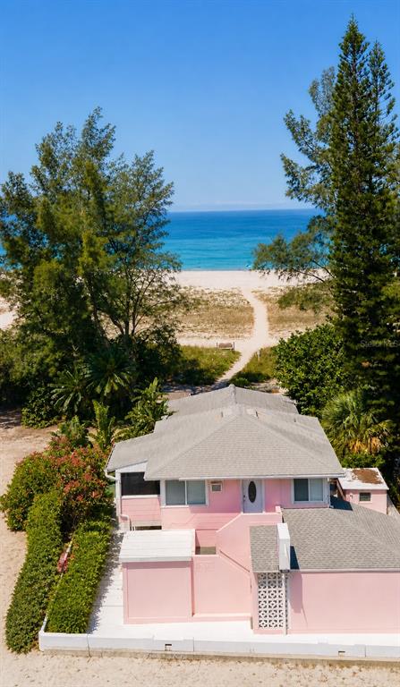 An aerial view of a pink beach house with a gray roof near the ocean — 10200 GULF BOULEVARD, TREASURE ISLAND, FL