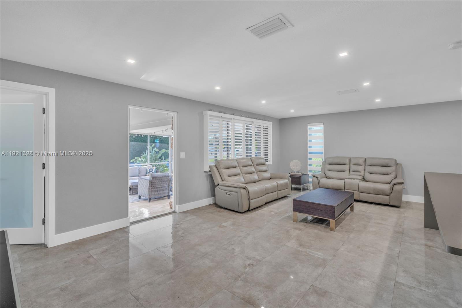 A living room features gray walls, tile flooring, two leather sofas, and a coffee table — 222 2nd Rd, Key Largo FL 33037, KEY LARGO, FL