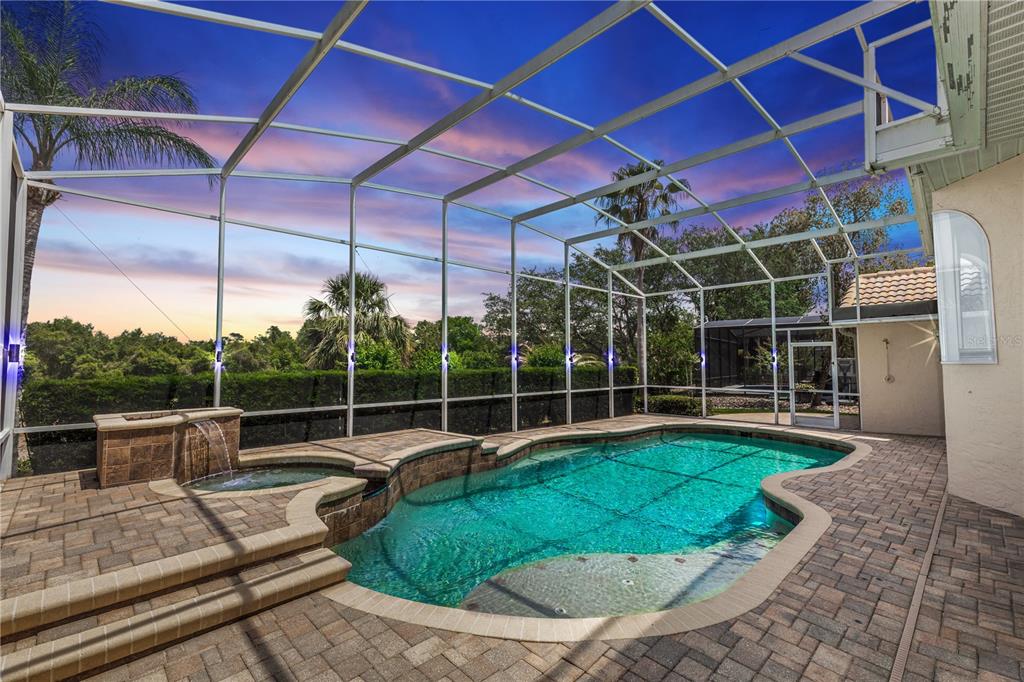 A screened-in patio features a swimming pool, a raised spa, and brick paver decking — 340 HAMPTON HILLS COURT, DEBARY, FL