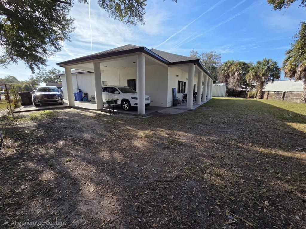 A white house features a large covered carport supported by columns and a spacious yard — 5602 CHARLES DRIVE, TAMPA, FL