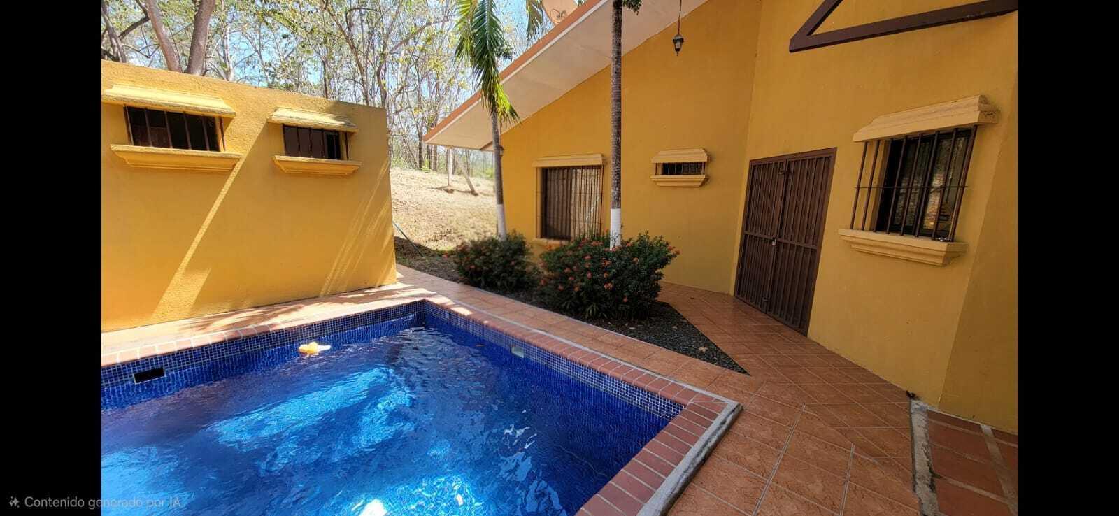 A yellow house exterior features a small blue tiled swimming pool and a patio area — De Estación Bomberos 1km Norte 3km Al Oeste, FL