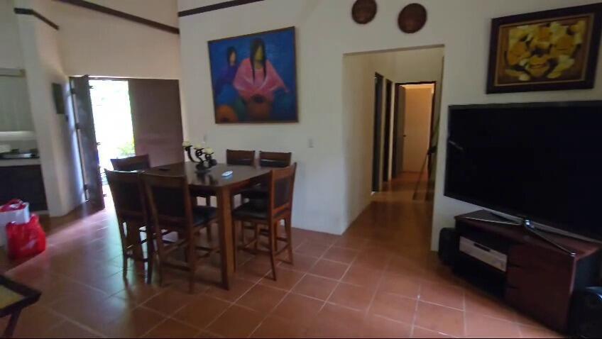 A dining area with a wooden table and chairs sits next to a living room — De Estación Bomberos 1km Norte 3km Al Oeste, FL