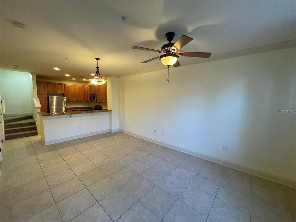 An open-concept living area features tile flooring, a ceiling fan, and an adjacent kitchen — 2846 BELLA VISTA DRIVE, DAVENPORT, FL