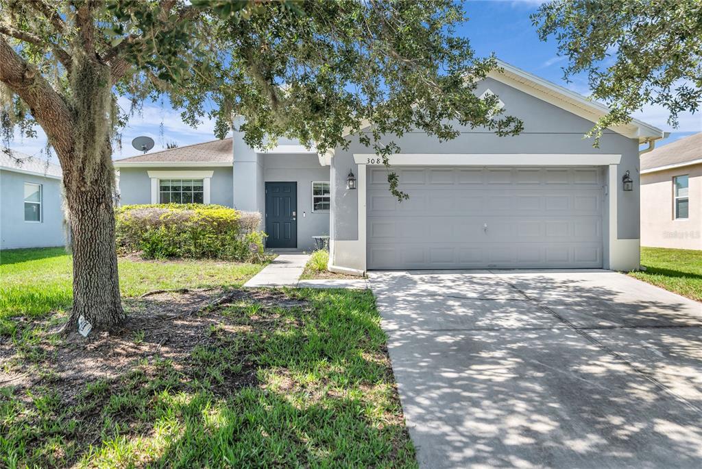 A single-story house with a gray exterior, a two-car garage, and a front lawn — 308 BELLA ROSA CIRCLE, SANFORD, FL