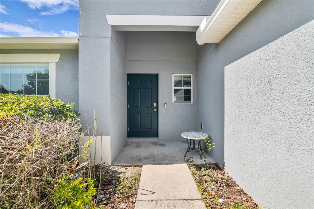 The exterior entrance features a dark door, a small side window, and a concrete walkway — 308 BELLA ROSA CIRCLE, SANFORD, FL