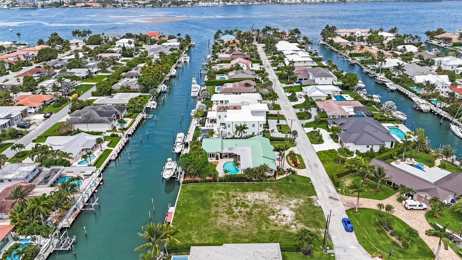 An aerial view shows waterfront homes with private docks and pools along a canal — 1121 Coral Way, Singer Island FL 33404, SINGER ISLAND, FL