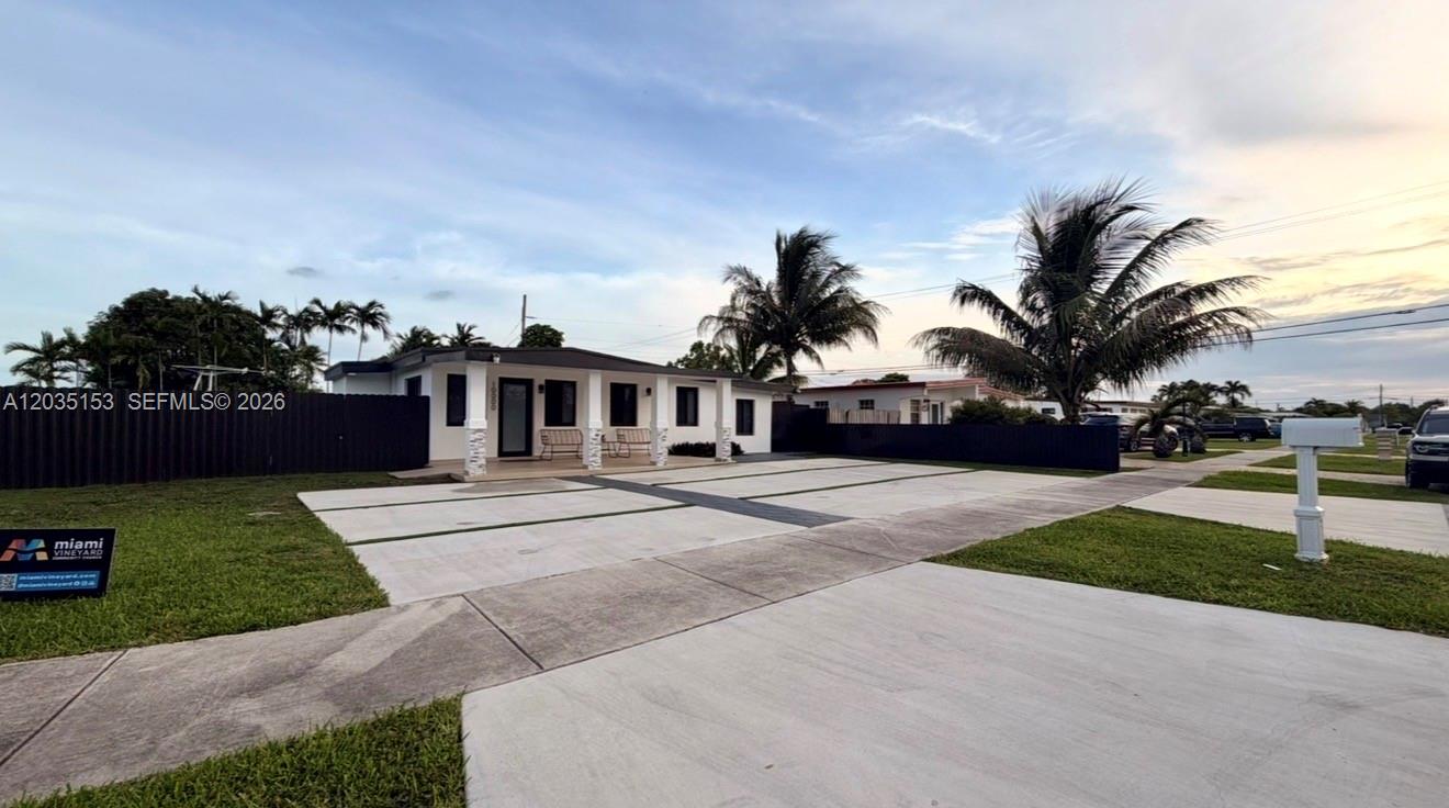 A single-story house with a large concrete driveway and a black fence — 10000 SW 43rd St, Miami FL 33165, MIAMI, FL