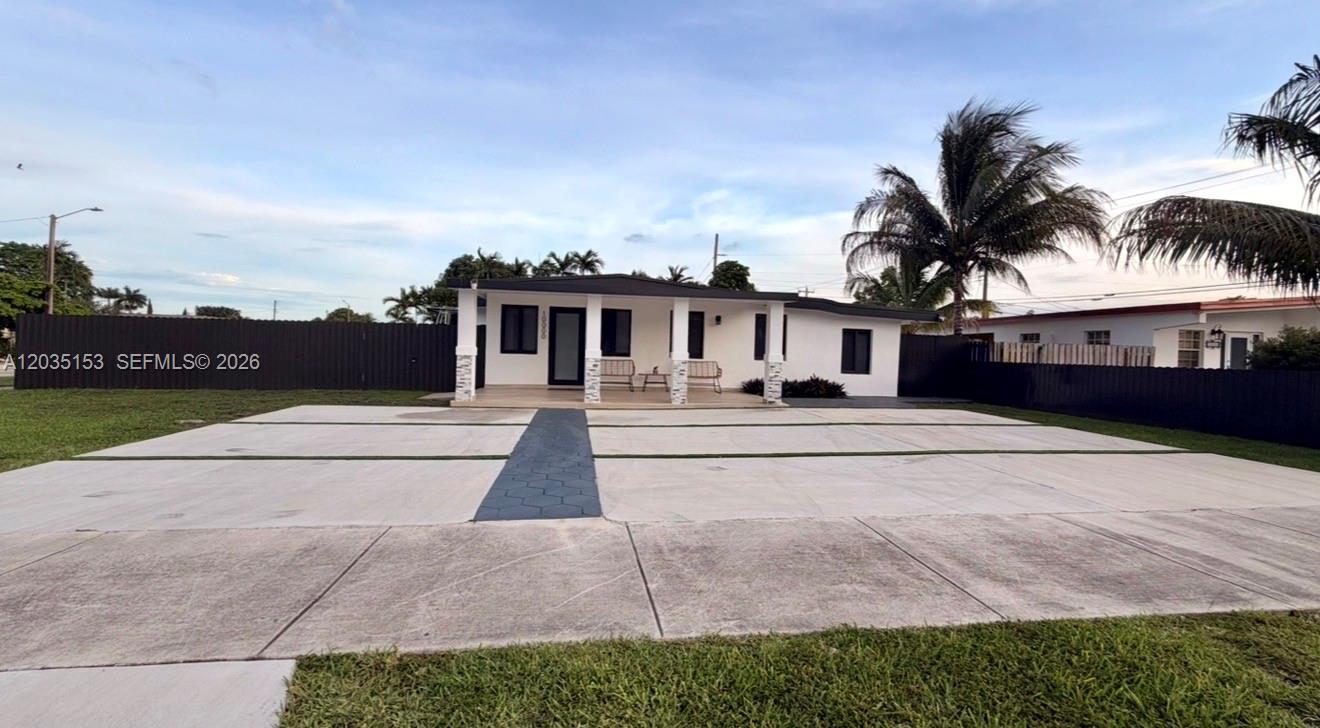 A single-story white house features a large concrete driveway and a covered front porch — 10000 SW 43rd St, Miami FL 33165, MIAMI, FL