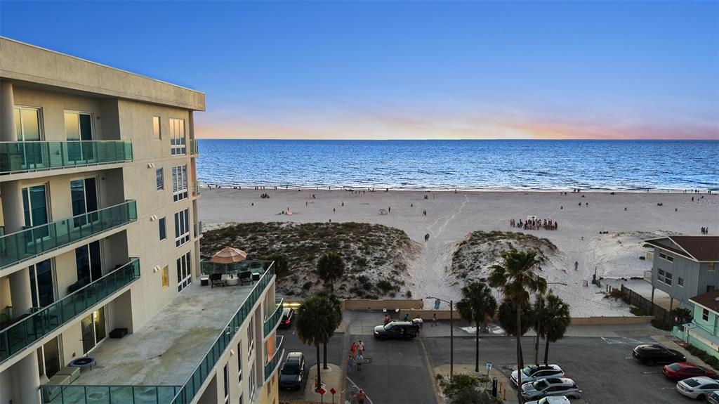 An elevated view of a beachside condominium building overlooking a sandy beach and ocean — 15 AVALON STREET UNIT 502, CLEARWATER BEACH, FL