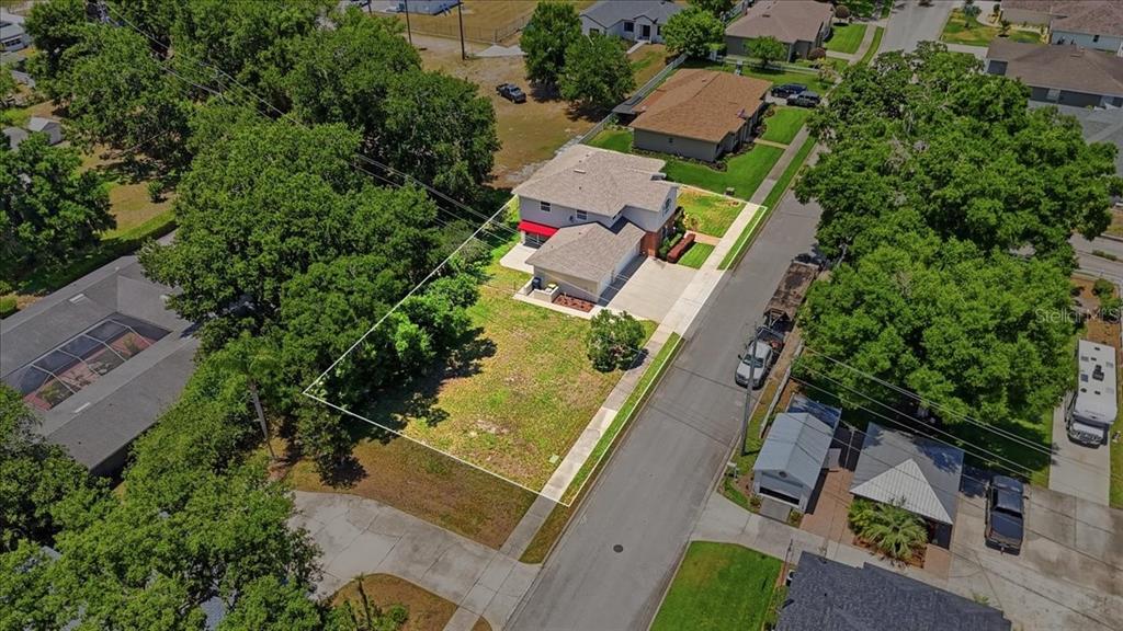An aerial view shows a two-story house with a large, grassy side yard — 1503 AUBURN OAKS BOULEVARD, AUBURNDALE, FL