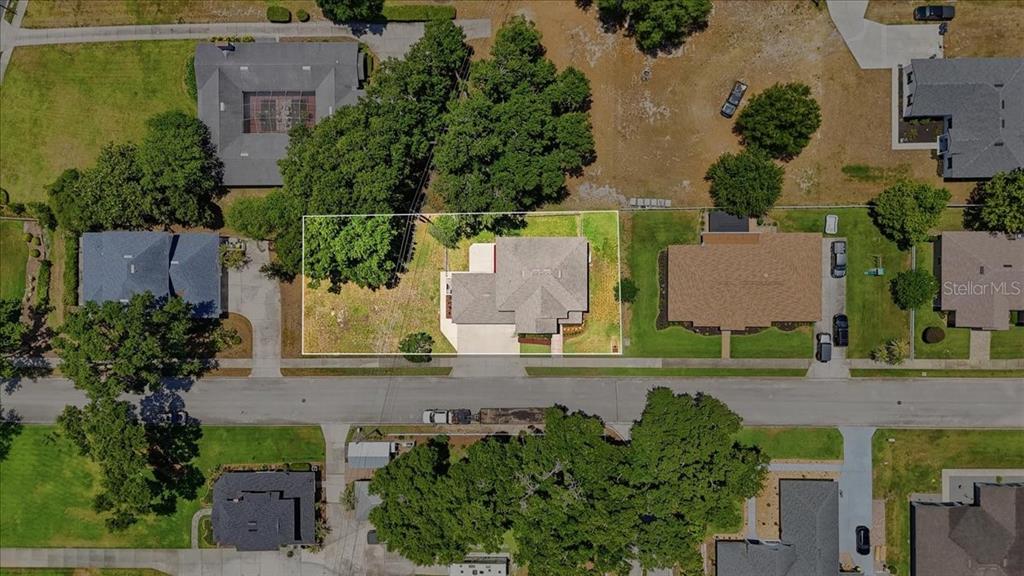 An aerial view shows a single-story house with a gray roof on a landscaped lot — 1503 AUBURN OAKS BOULEVARD, AUBURNDALE, FL