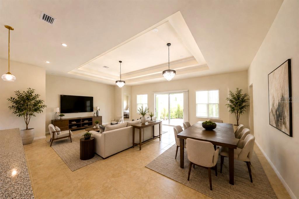 An open-concept living and dining area features a tray ceiling, tile floors, and neutral decor — 8322 PARK CLIFF WAY, ORLANDO, FL
