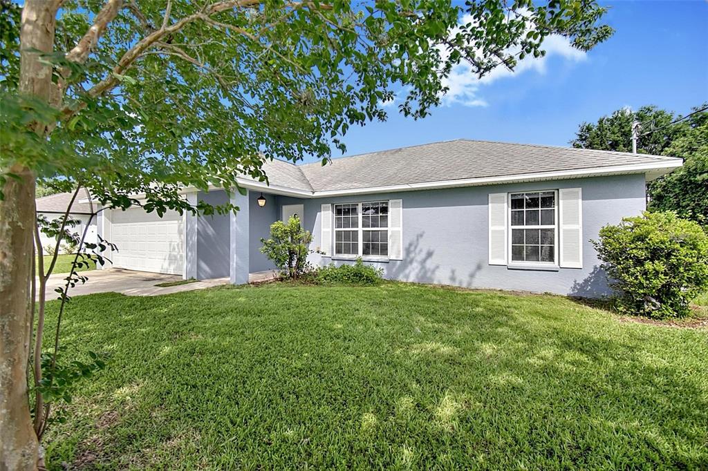 A light blue single-story house with a two-car garage and a front lawn — 9 LYTTON LANE, PALM COAST, FL