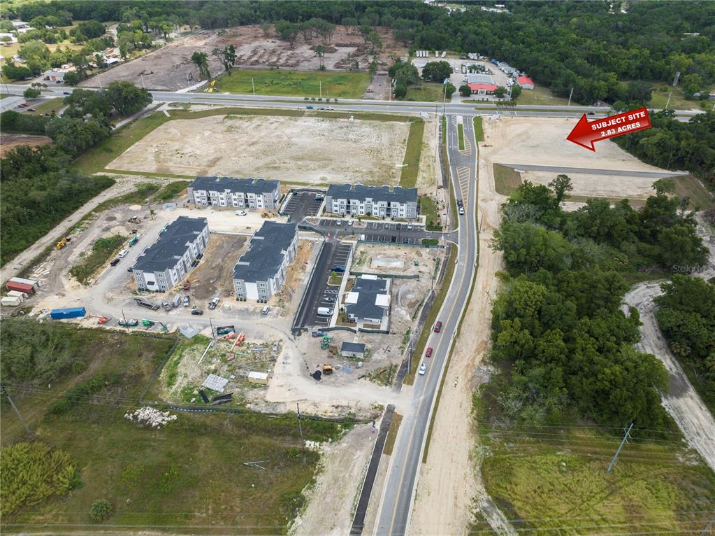 An aerial view shows a construction site with several multi-story buildings and a cleared lot — NW 35TH STREET, OCALA, FL