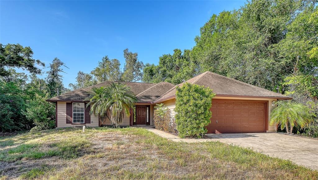 A single-story house with a brown roof, tan siding, and a two-car garage — 2452 ASHTON ROAD, SARASOTA, FL
