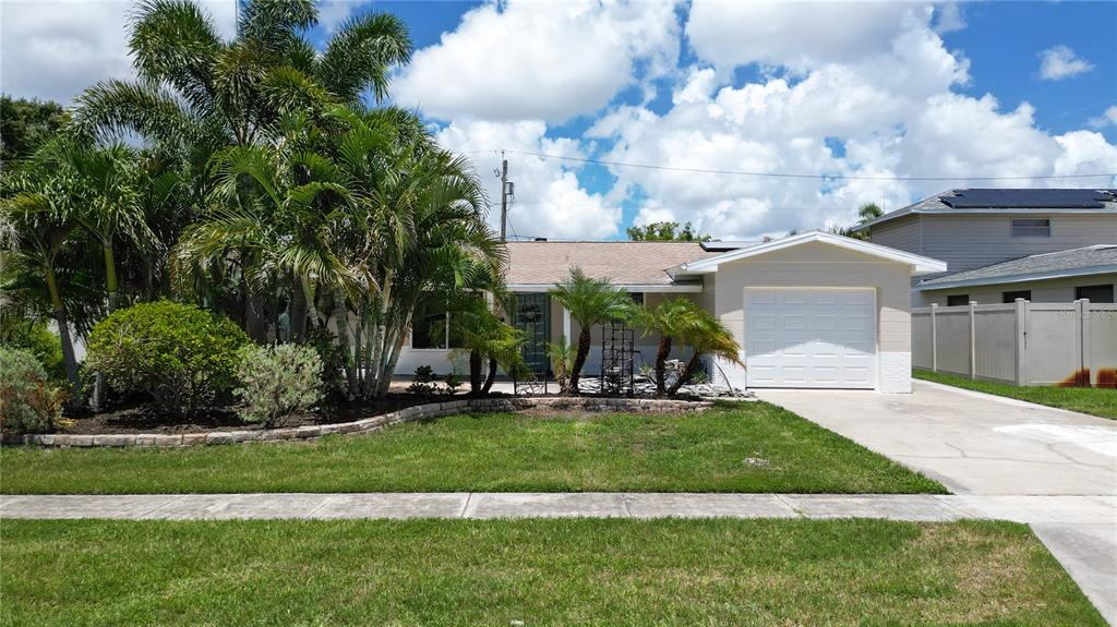 A single-story house with a white garage, palm trees, and a front lawn — 6065 23RD AVENUE N, ST PETERSBURG, FL