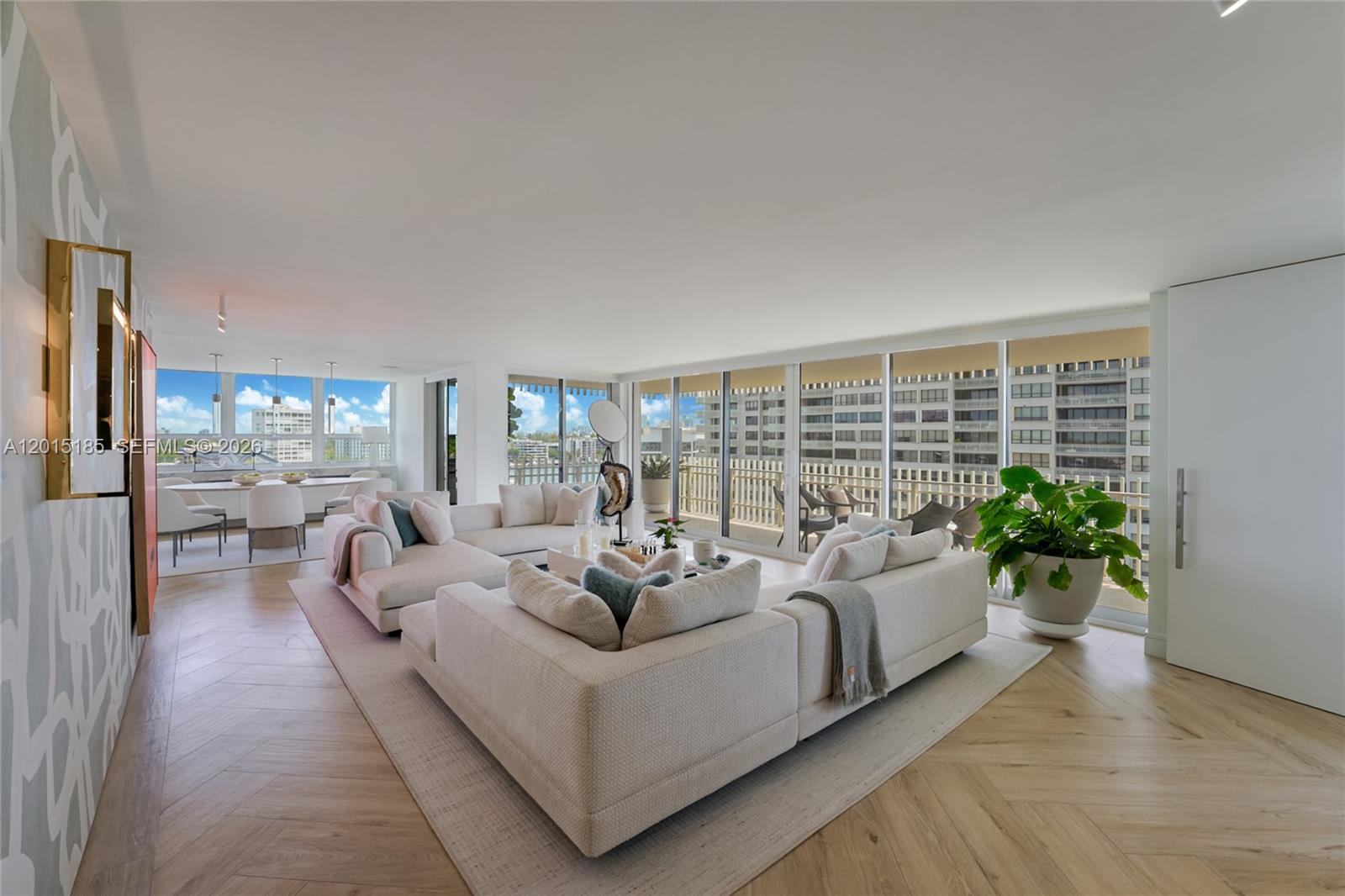 A spacious living room features a large sectional sofa, herringbone wood floors, and floor-to-ceiling windows — 1 Grove Isle Dr # A809, Miami FL 33133, MIAMI, FL