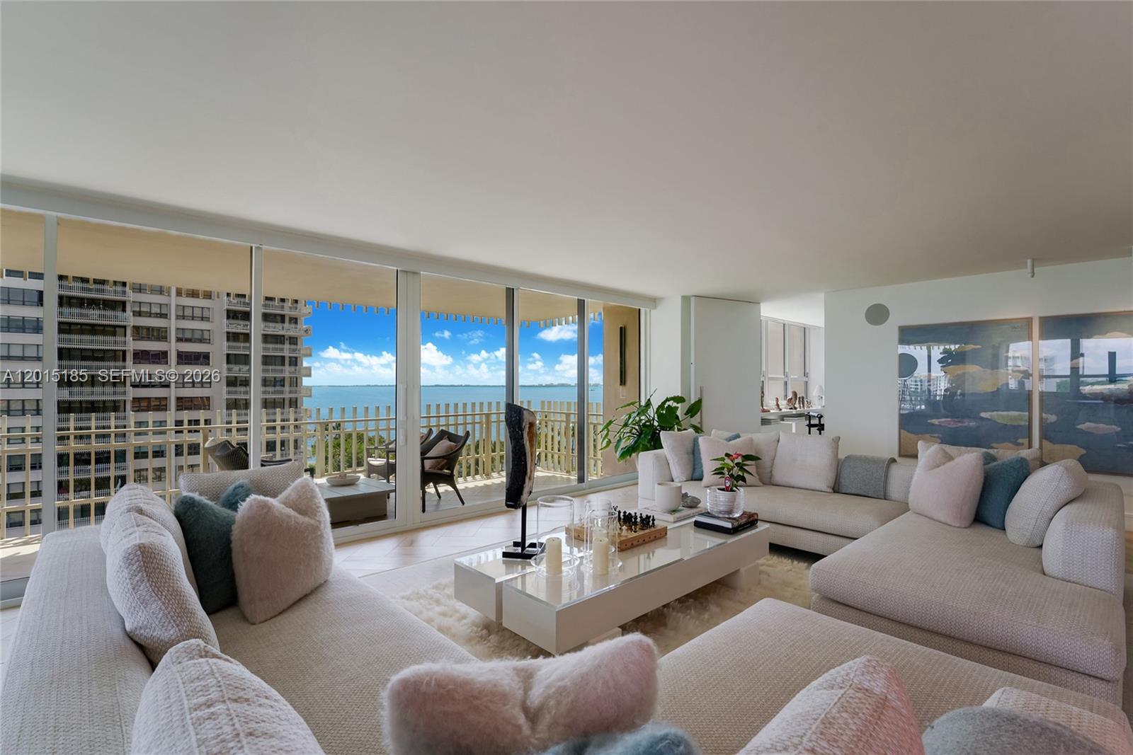 A bright living room features a large sectional sofa, glass coffee table, and balcony ocean views — 1 Grove Isle Dr # A809, Miami FL 33133, MIAMI, FL