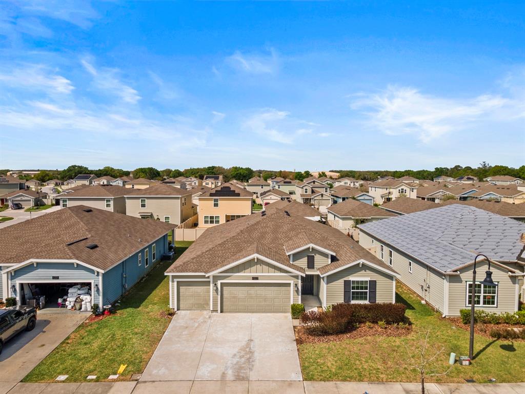 An aerial view shows a suburban neighborhood with single-family homes and paved driveways — 4327 LIGHTERKNOT TRACE, KISSIMMEE, FL