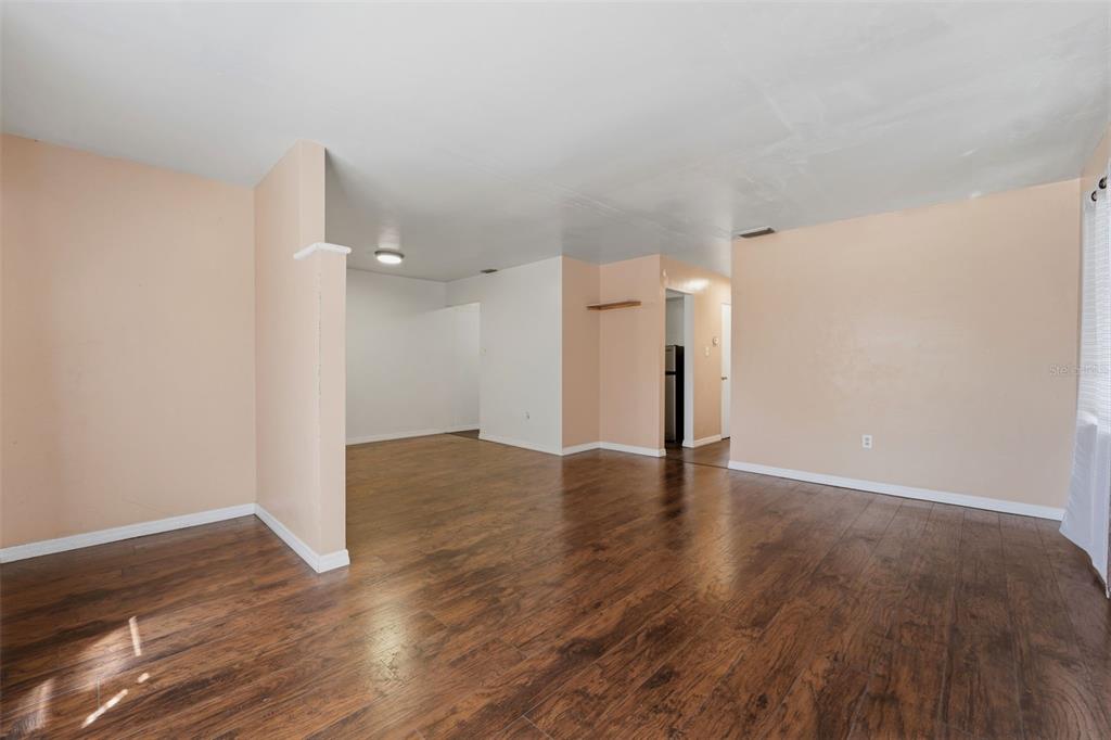 An empty room with light-colored walls and dark wood-look flooring — 3235 EMERSON AVENUE S, ST PETERSBURG, FL