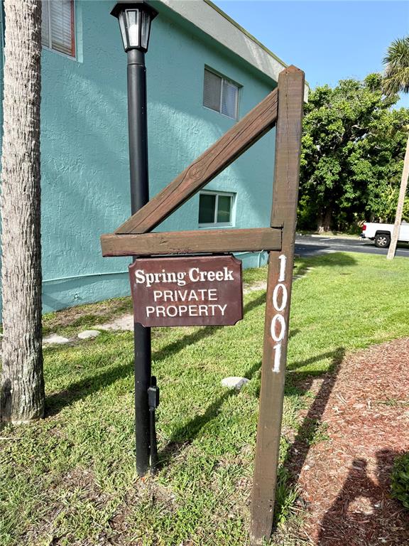 A wooden sign for Spring Creek Private Property stands in front of a teal building — 1001 W EAU GALLIE BOULEVARD UNIT 217, MELBOURNE, FL