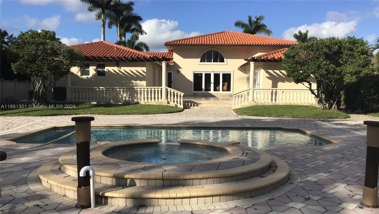 A backyard features a swimming pool, a circular spa, and a house with a tiled roof — 13460 SW 32nd ST, Kendall FL 33175, KENDALL, FL