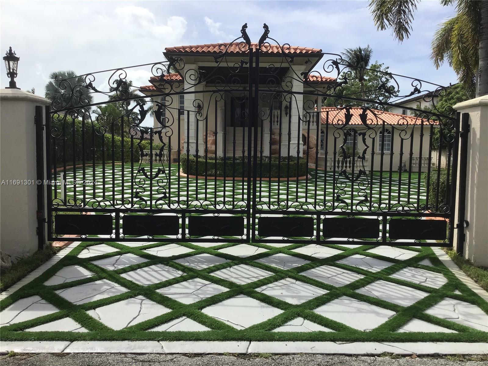 A black wrought iron gate stands before a house with a diamond-patterned paver driveway — 13460 SW 32nd ST, Kendall FL 33175, KENDALL, FL
