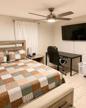 A bedroom features a bed with a patchwork quilt, a desk with a chair, and a television — 2123 NE 6th Ave, Cape Coral FL 33909, CAPE CORAL, FL