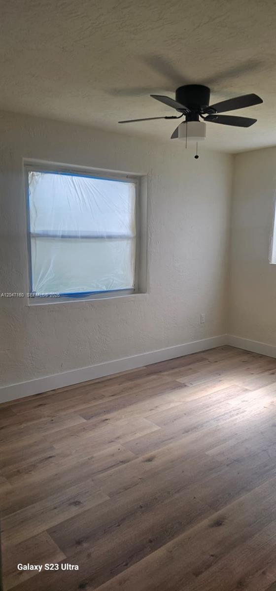 An empty bedroom features light wood-look flooring, white walls, and a black ceiling fan — 6010 SW 33rd St, Miramar FL 33023, MIRAMAR, FL