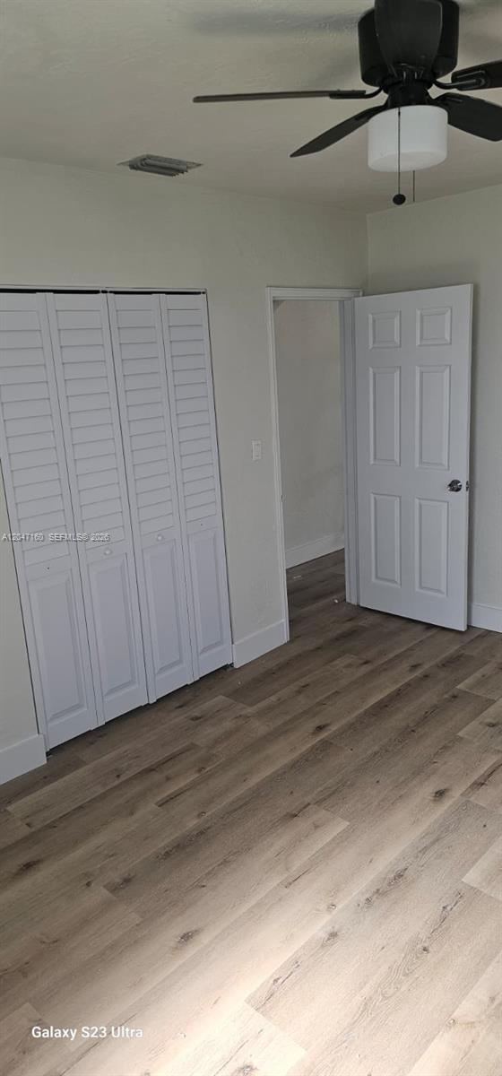 A bedroom features light wood-look flooring, white louvered closet doors, and a ceiling fan — 6010 SW 33rd St, Miramar FL 33023, MIRAMAR, FL