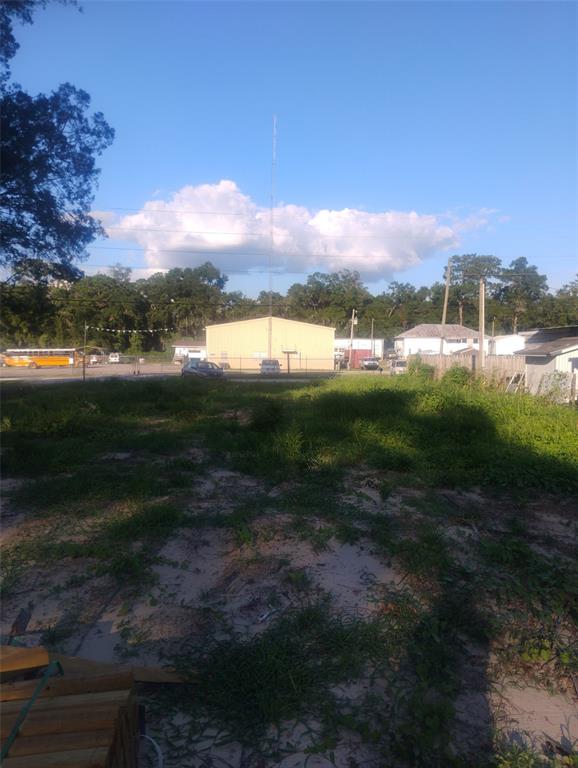 A gravel lot features a small shed, storage tanks, and a chain-link fence — 587 MARSHBURN DRIVE, BRONSON, FL