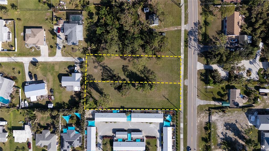 This aerial view shows a vacant rectangular lot outlined in yellow next to a road — OLD ENGLEWOOD ROAD, ENGLEWOOD, FL