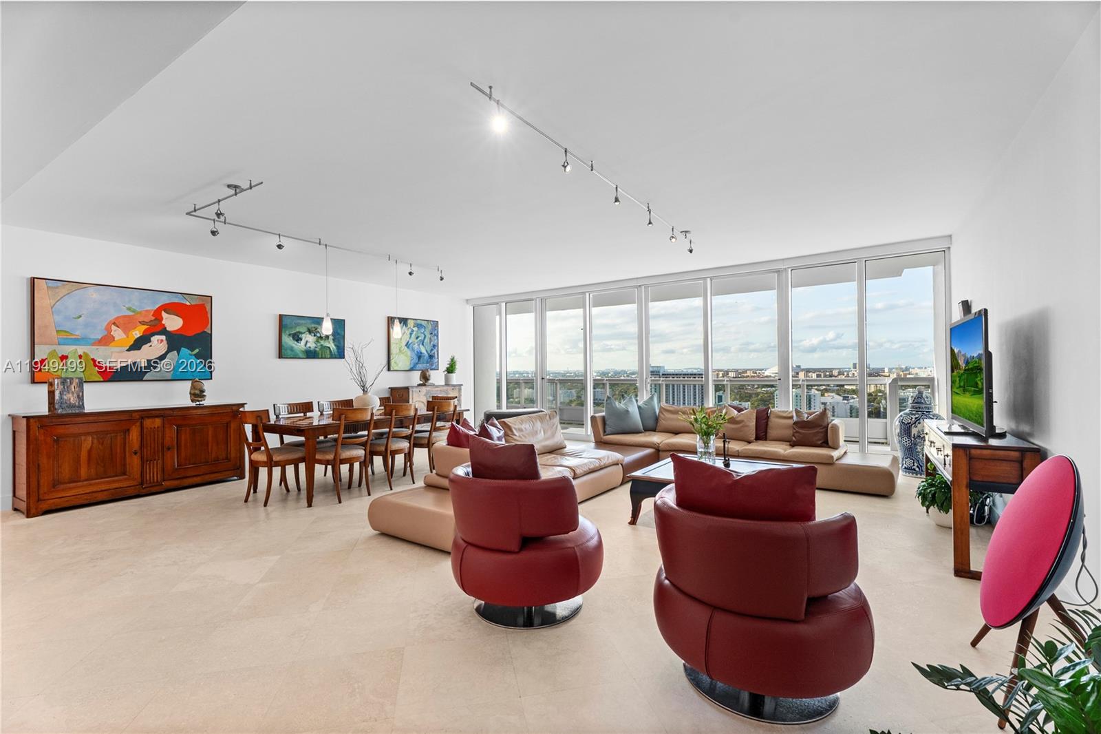 A spacious living and dining area features tile floors, floor-to-ceiling windows, and modern furniture — 1643 Brickell Ave # 2506, Miami FL 33129, MIAMI, FL