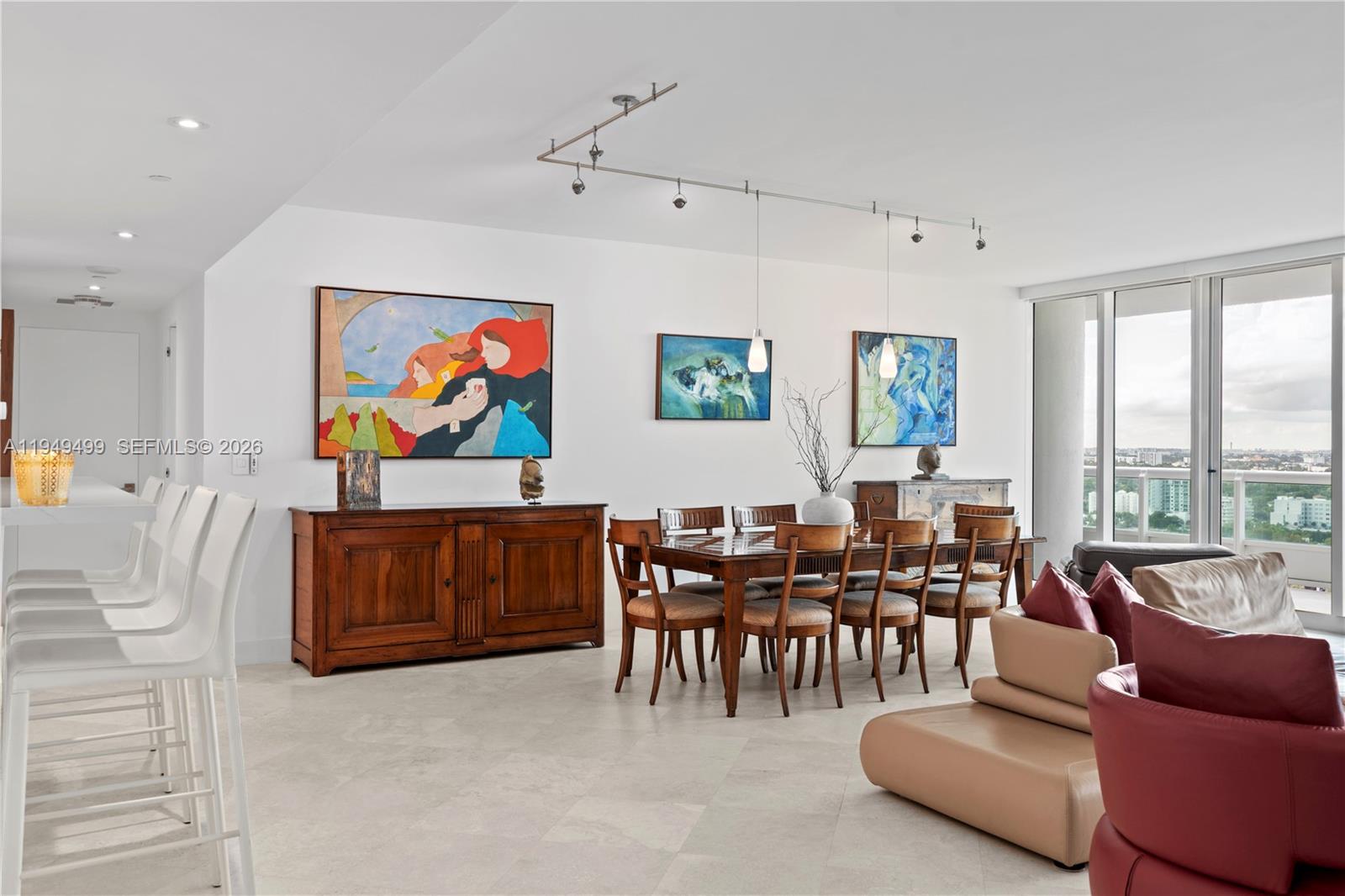 A dining area with a wooden table and chairs sits adjacent to a living space — 1643 Brickell Ave # 2506, Miami FL 33129, MIAMI, FL