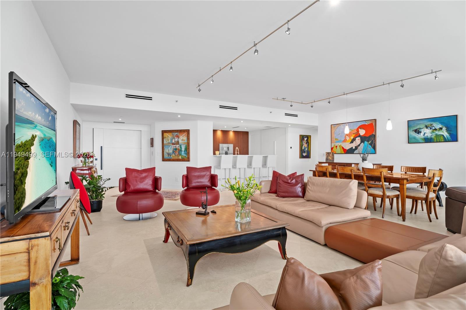 A spacious living and dining area features neutral tile floors, modern lighting, and colorful artwork — 1643 Brickell Ave # 2506, Miami FL 33129, MIAMI, FL