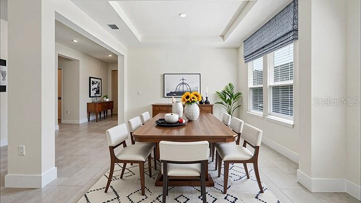 A dining room features a wooden table, six chairs, and a tray ceiling — 11367 CURIO DRIVE, BROOKSVILLE, FL