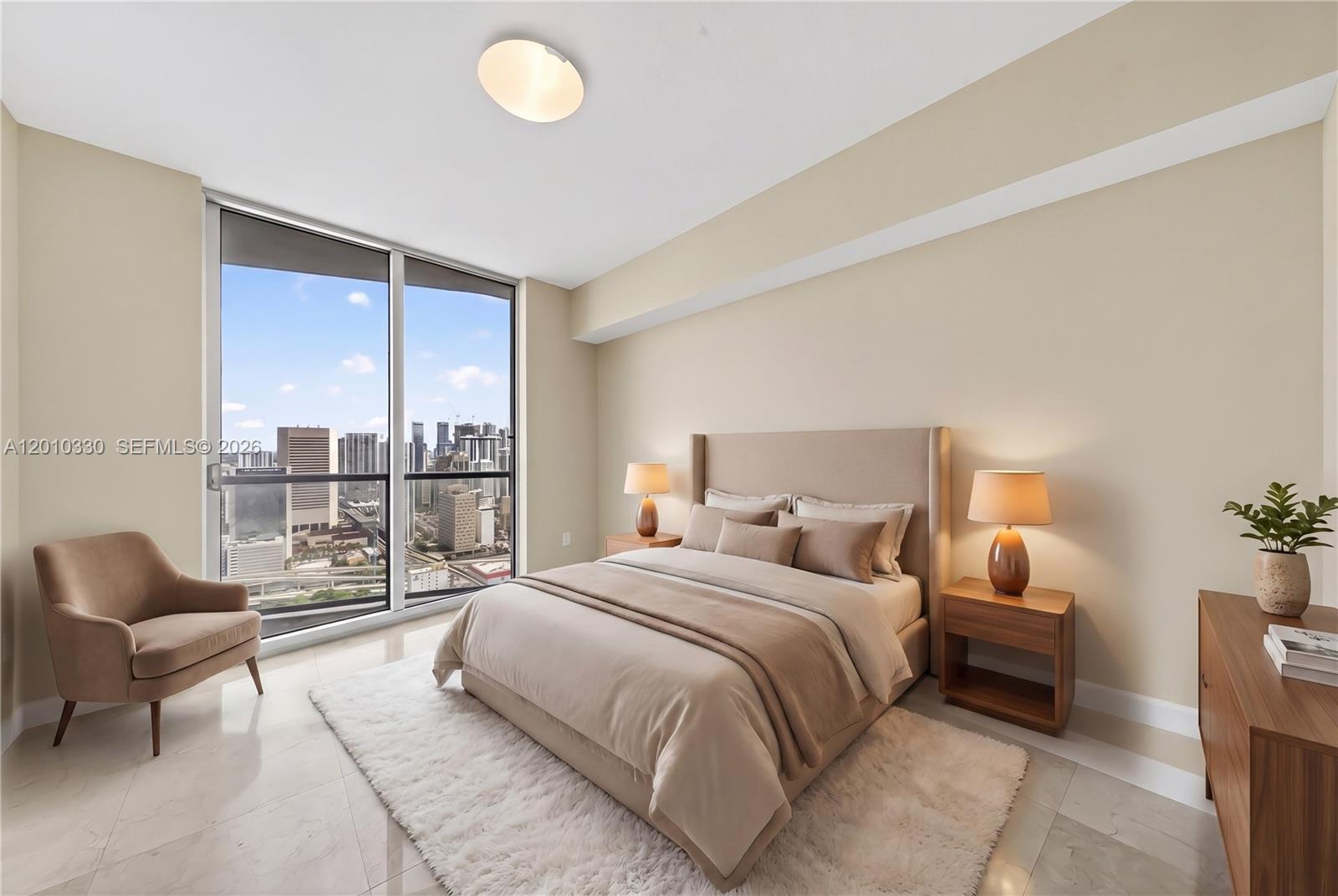 A modern bedroom features a bed, two nightstands, an armchair, and floor-to-ceiling windows with city views — 185 SW 7th St # 4209, Miami FL 33130, MIAMI, FL